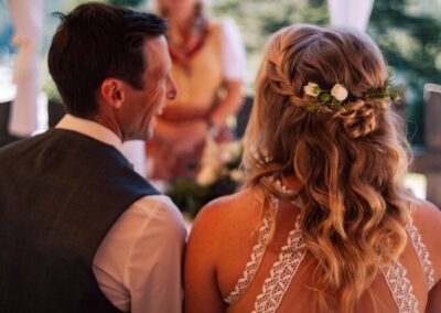 Locken romantisch für Hochzeit, Bild von hintern, blonde Haare in Wellen gelegt mit Blumenschmuck im Haar