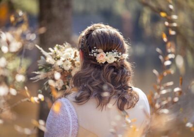 Romantische Wellen Hochzeitsfrisur mit Blumenschmuck im Haar von hinten